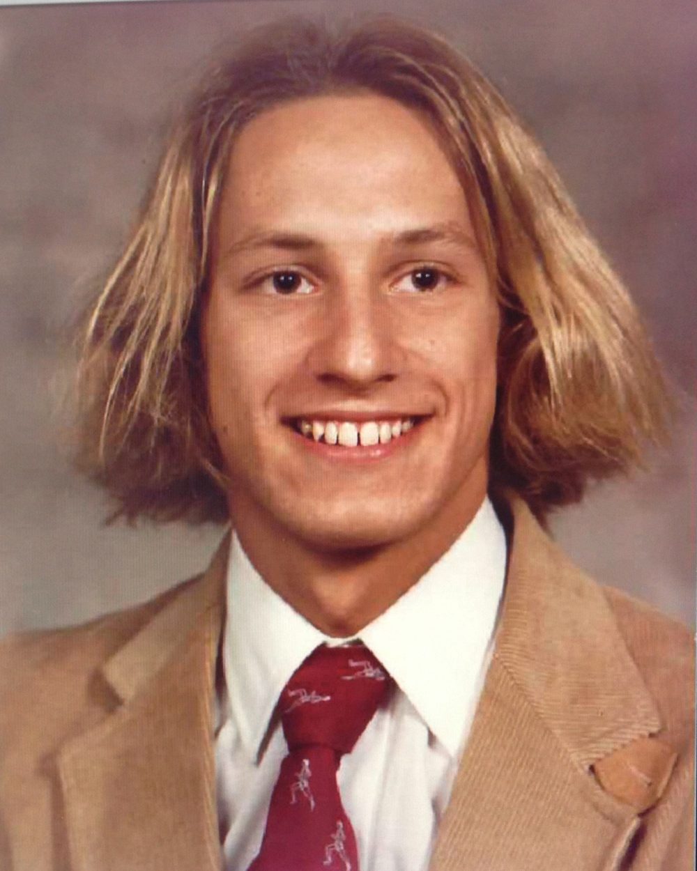 Ben’s high-school portrait: long blond hair, tan jacket and red tie